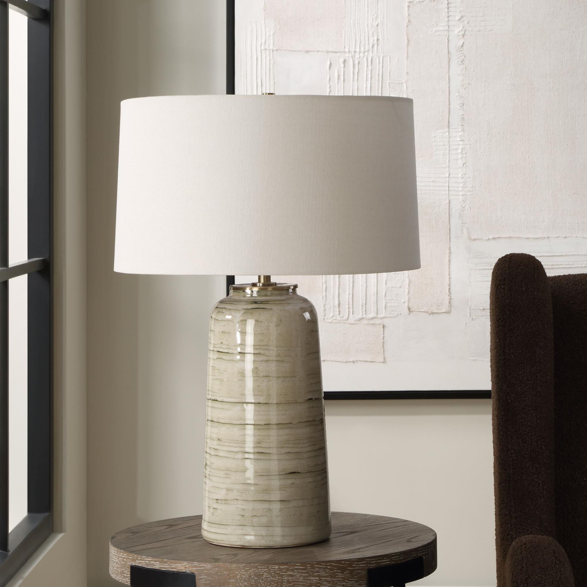 Shown in This Ceramic Table Lamp Features A Greenish Tan Glaze With Dark Undertones, Accented With Plated Ant finish and Round Hardback shade