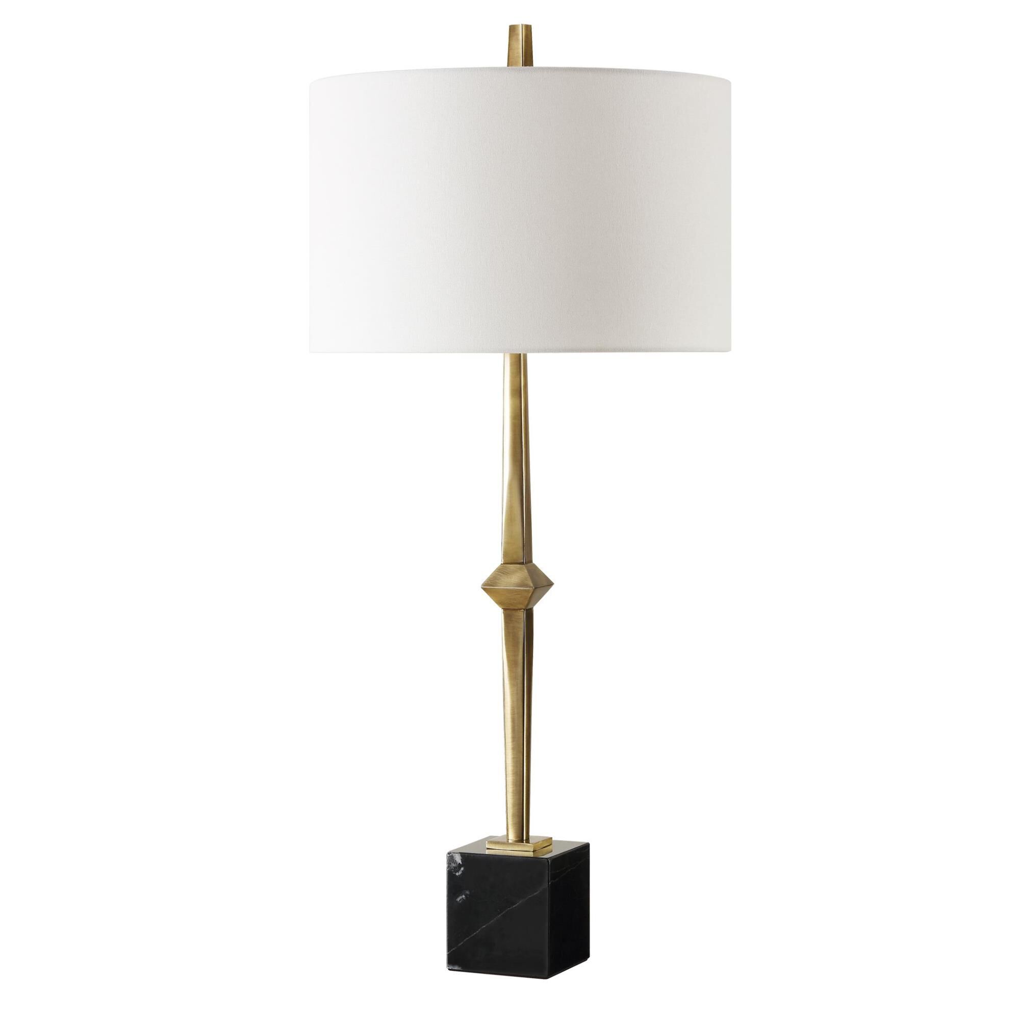 Shown in The Suranne Table Lamp Features A Slender Metal Column In A Sophisticated Plated Antique Brass Finis finish and Round Drum Hardback shade