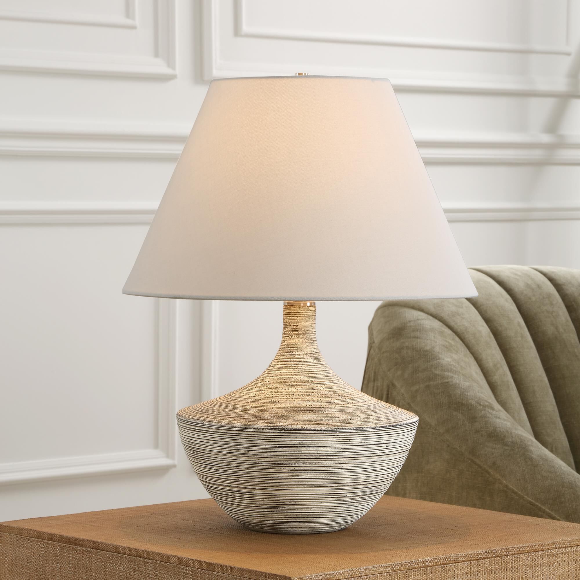 Shown in Where Vintage Charm Meets Contemporary Design, The Carafe Table Lamp Features A Charcoal Ceramic Bas finish and Round Hardback shade