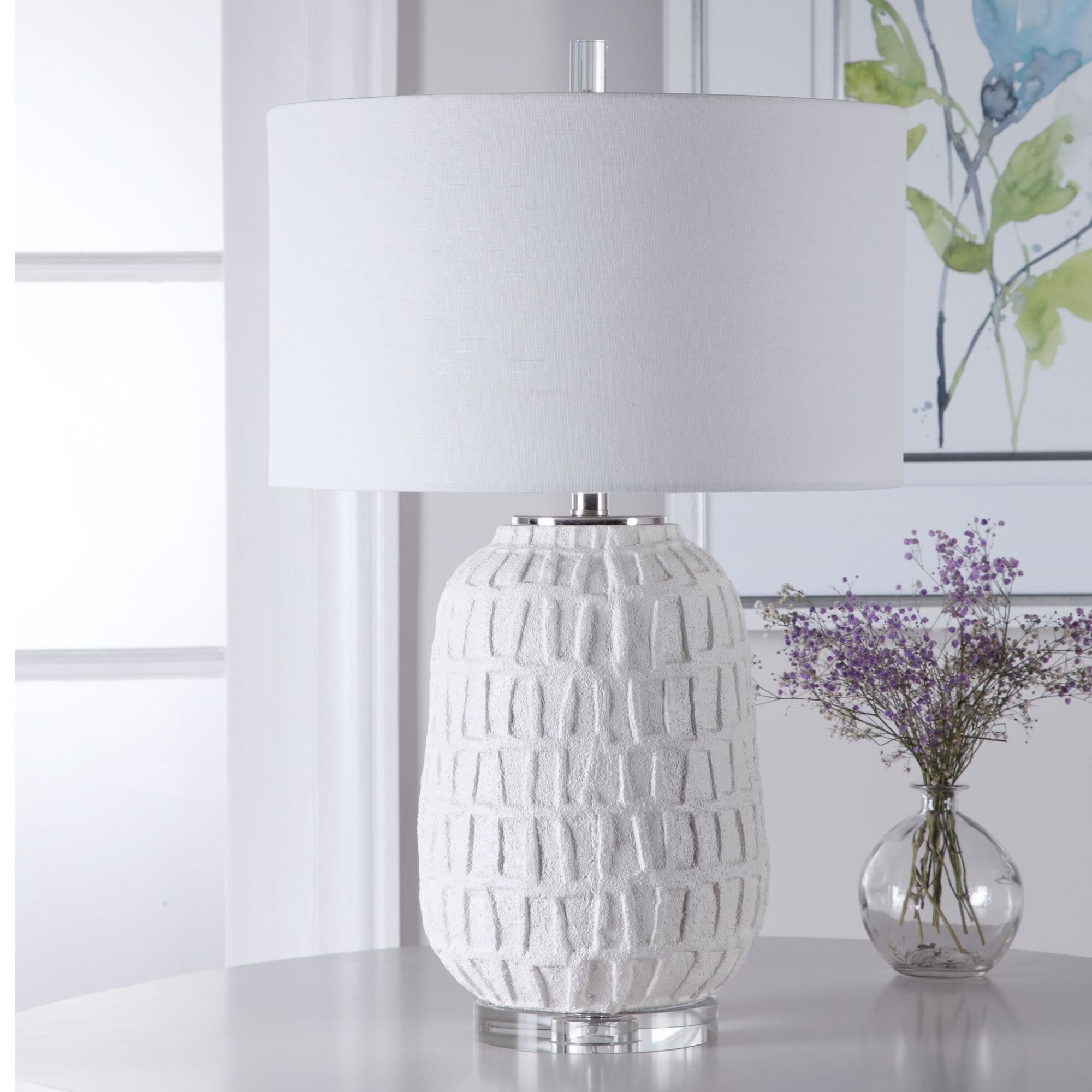 Shown in A Modern Take On Old World Style, This Table Lamp Features A Textured, Matte White Ceramic Base With finish and Drum Hardback  Rolled Edge shade