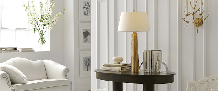 Visual Comfort gold table lamp on a living room end table by Capitol Lighting.