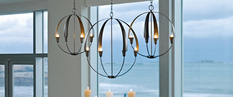 Trendy chandelier lighting fixtures from Capitol Lighting hanging above a dining room table.